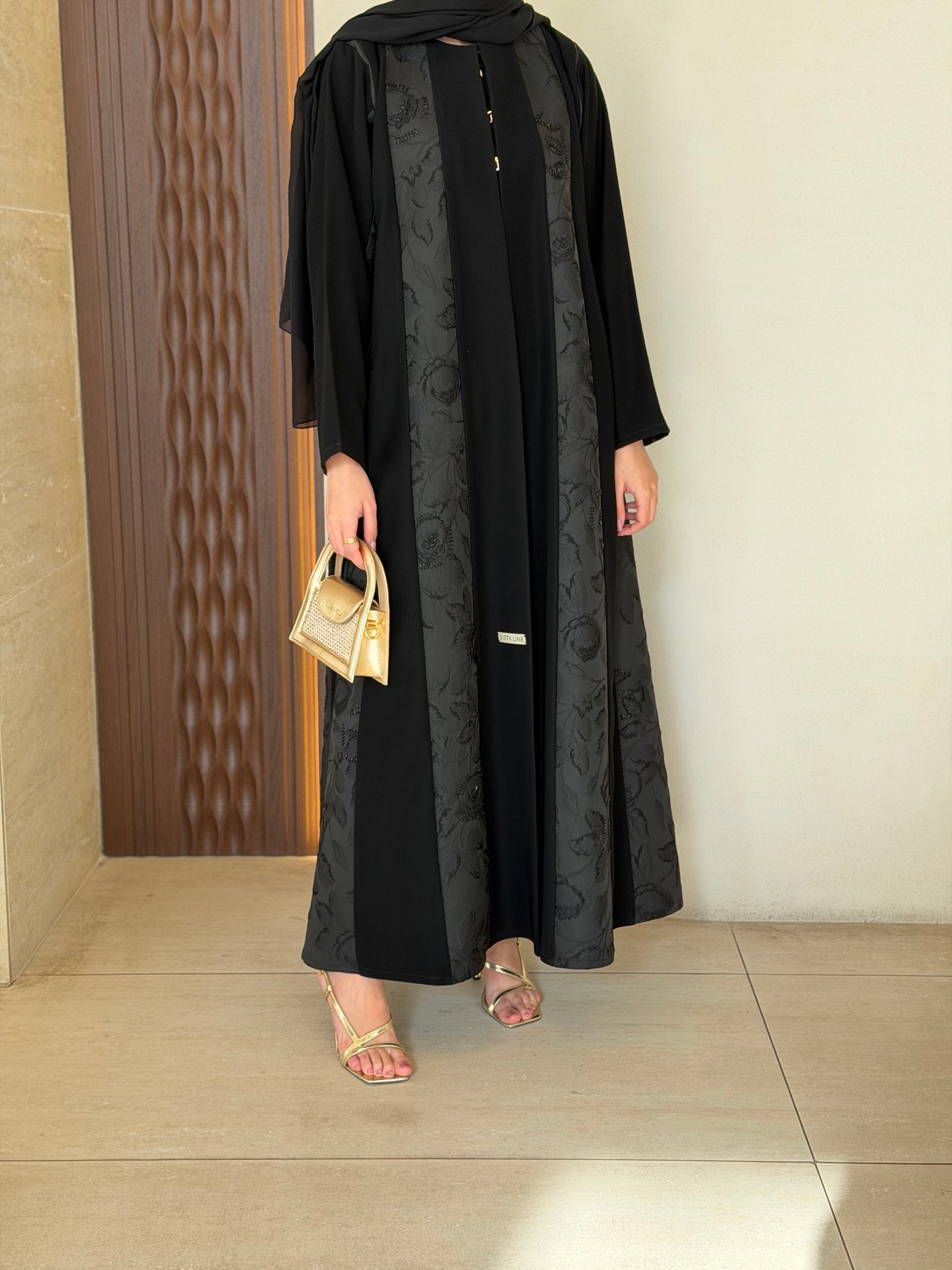 A cloche-style abaya combining two fabrics